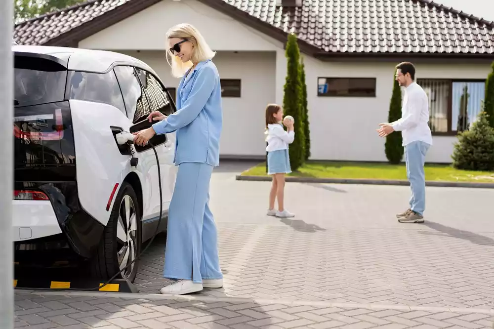 family-charging-electric-car-outside-modern-house-2024-07-04-00-14-16-utc